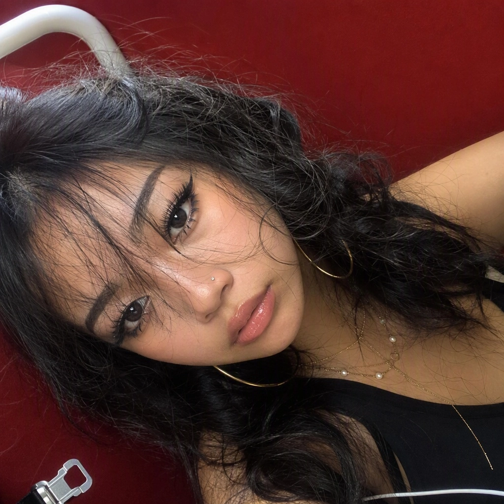 Extremely tilted close-up smartphone selfie of a young East Asian woman in her late teens or early 20s, face rotated alm